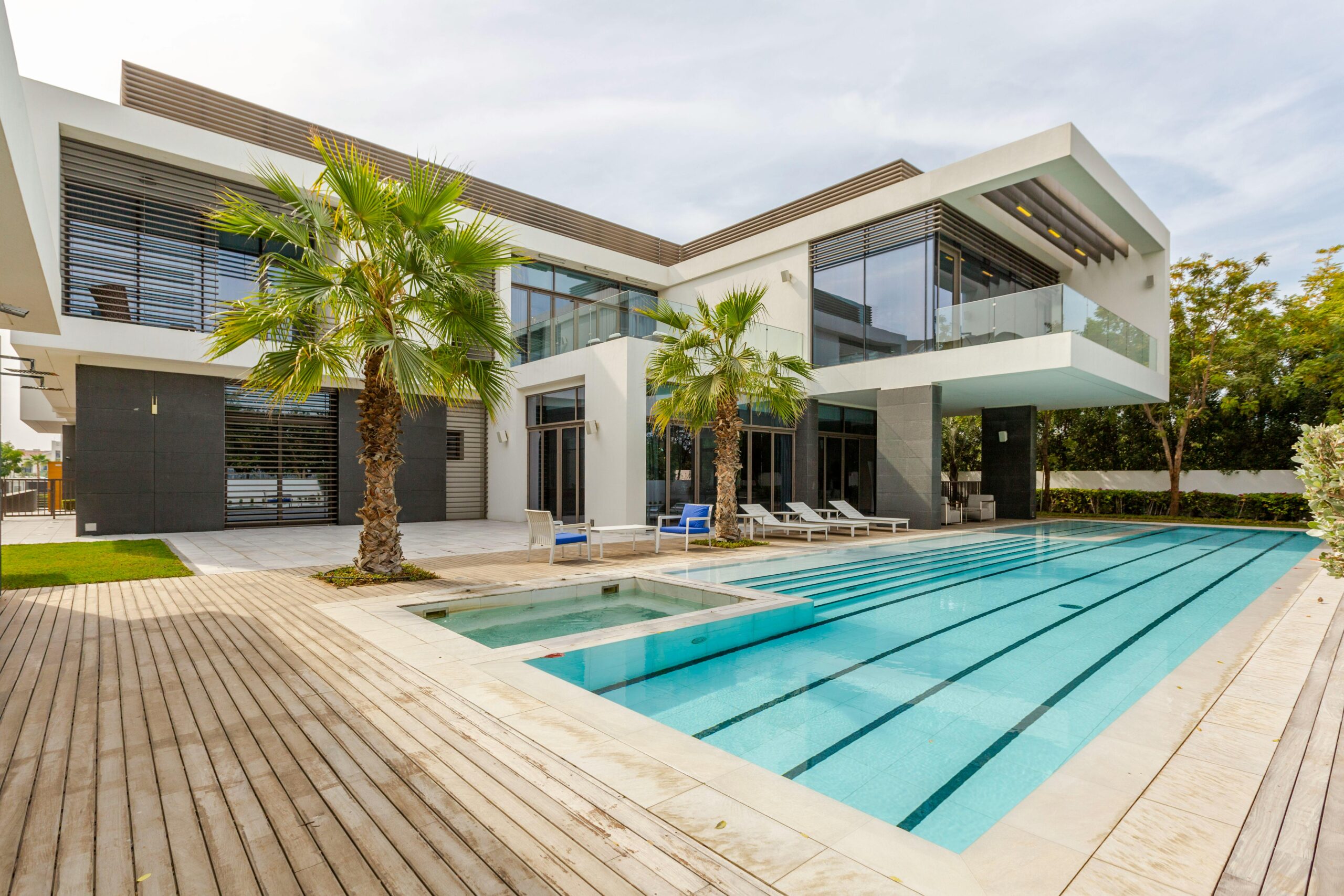 Explore this luxurious modern villa in Dubai with a stunning swimming pool and palm trees.