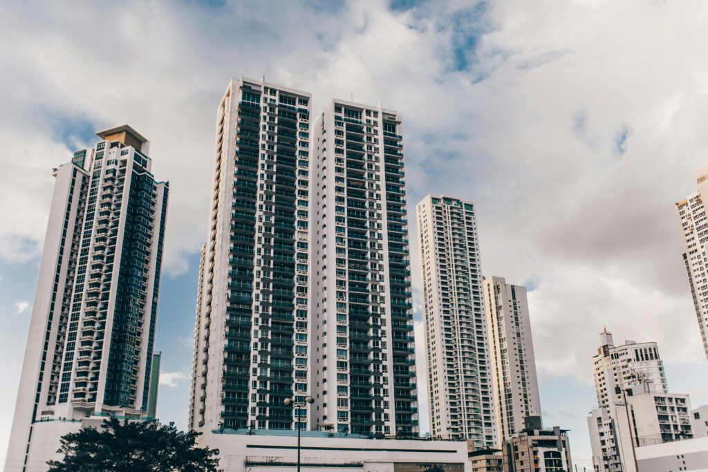 Urban skyline with tall skyscrapers under a partly cloudy sky, showcasing modern architecture.