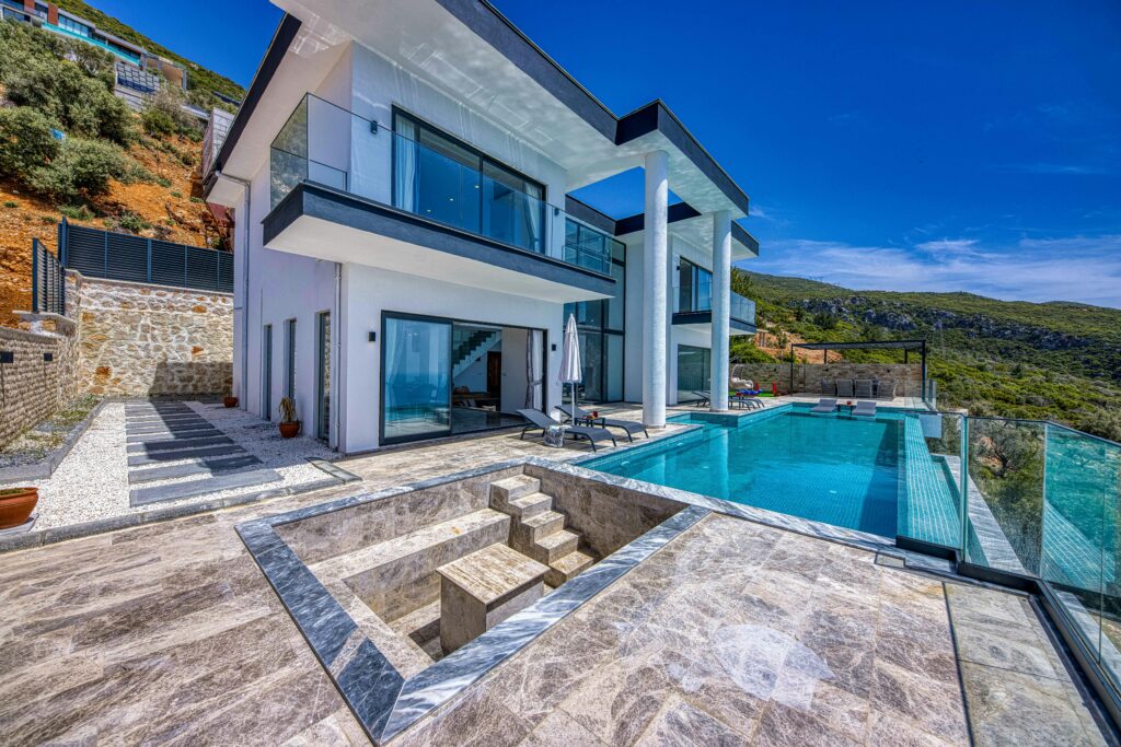 Stunning contemporary villa with glass, stone, and infinity pool; perfect for luxury living.