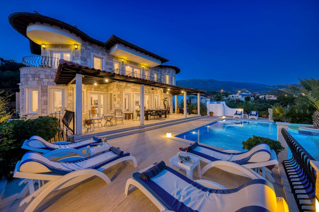 Stunning villa with poolside view during dusk, perfect for a luxurious vacation stay.
