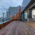 Empty spacious terrace with wooden floor and walls placed in modern apartment in cloudy day