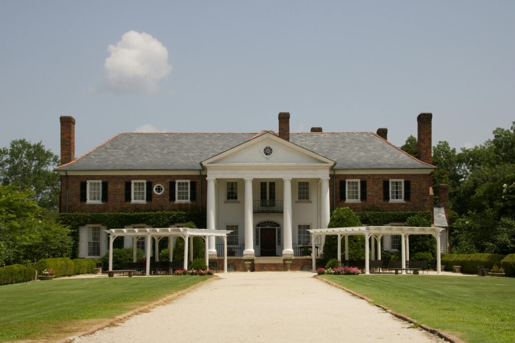 Elegant Southern-style mansion with white columns and lush gardens in Mount Pleasant, SC.